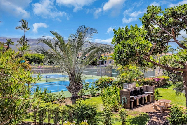 view of sport court featuring fence and a patio area