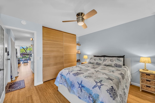bedroom with baseboards, light wood-type flooring, and a closet