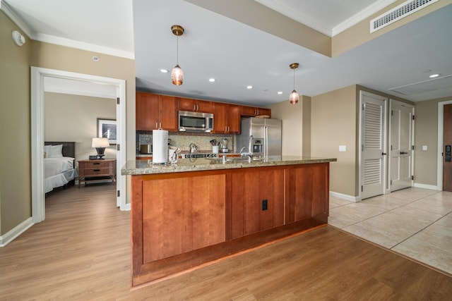 kitchen featuring appliances with stainless steel finishes, light wood-type flooring, backsplash, ornamental molding, and pendant lighting