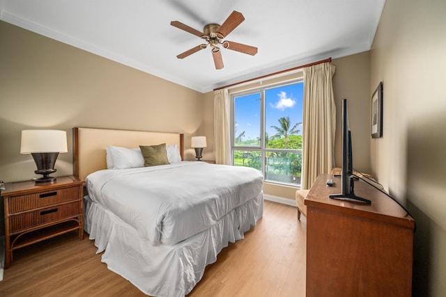 bedroom with ceiling fan, light wood-type flooring, and crown molding