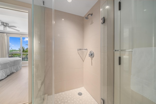 bathroom with ceiling fan and a shower with shower door