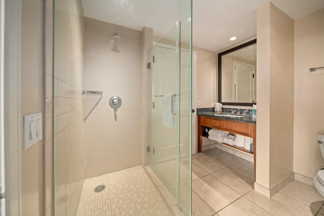 bathroom with tile patterned flooring, vanity, toilet, and a shower with shower door