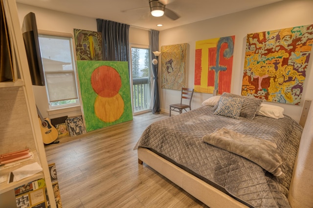 bedroom with access to exterior, wood finished floors, and a ceiling fan
