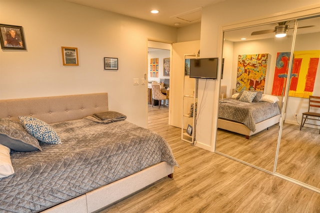 bedroom with a closet, wood finished floors, and recessed lighting