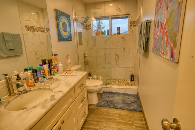 full bath featuring vanity, toilet, baseboards, a stall shower, and wood finished floors