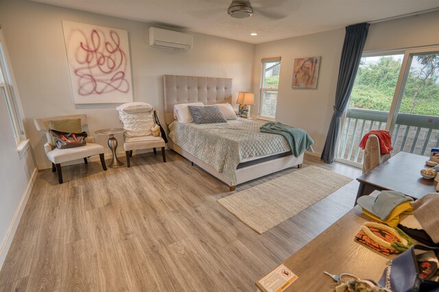 bedroom with a wall mounted air conditioner, baseboards, recessed lighting, access to exterior, and light wood-style floors