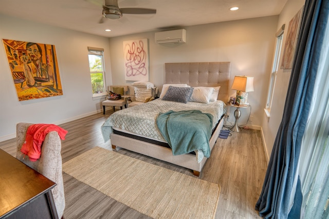 bedroom with a ceiling fan, light wood-style flooring, a wall mounted air conditioner, baseboards, and recessed lighting