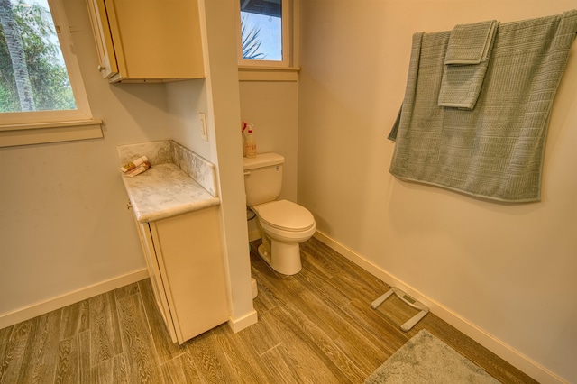 bathroom featuring baseboards, toilet, and wood finished floors