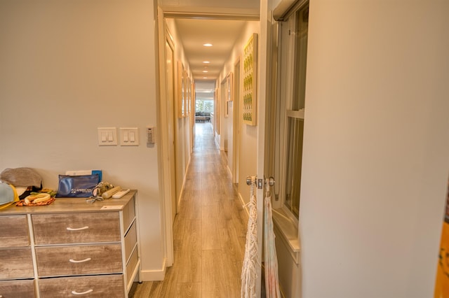 hall with baseboards and light wood-style floors