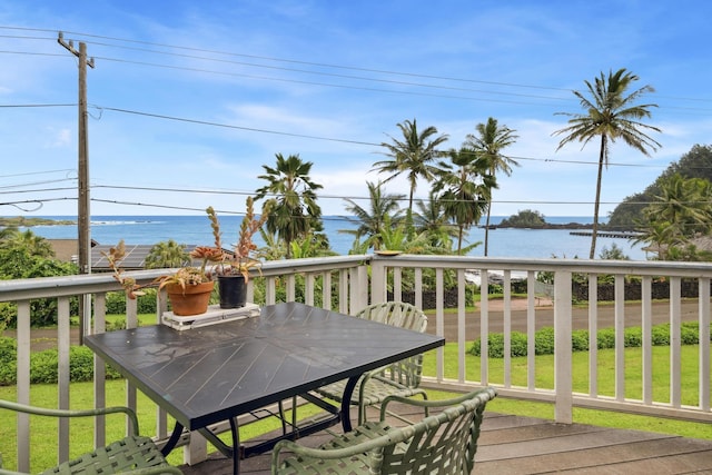 wooden deck featuring a water view, outdoor dining area, and a yard