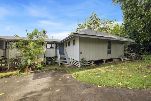 view of front of property featuring a shingled roof and a front yard