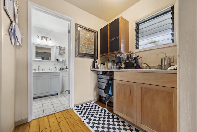 bathroom with wood-type flooring, vanity, and baseboards