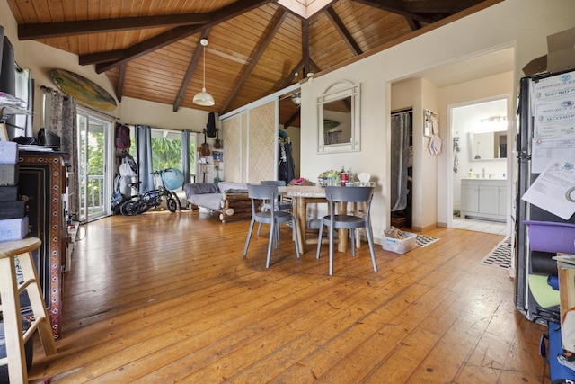 dining space featuring beamed ceiling, light wood-type flooring, a skylight, and wood ceiling