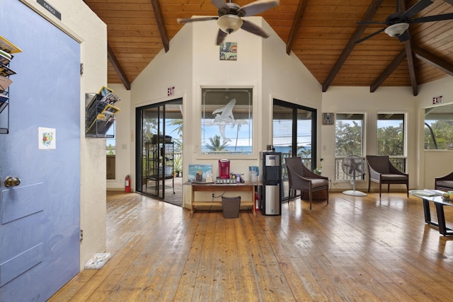 interior space with a ceiling fan, wooden ceiling, hardwood / wood-style floors, beamed ceiling, and high vaulted ceiling