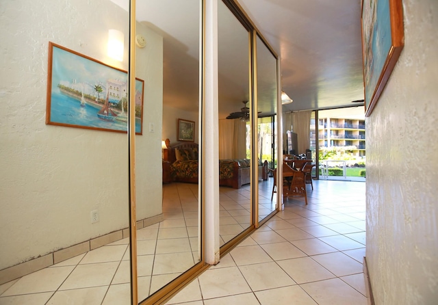 hallway featuring light tile patterned floors and a wall of windows