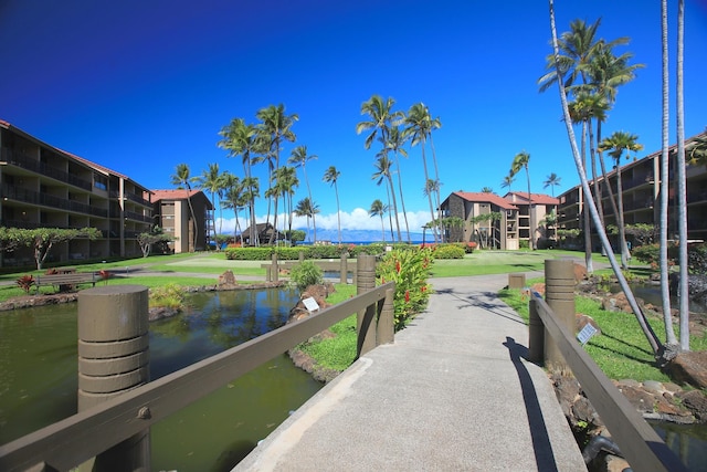 view of dock with a lawn and a water view