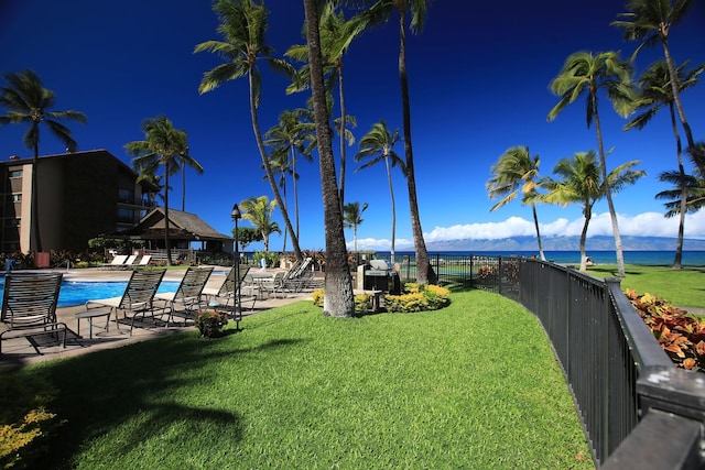 view of yard with a water view and a community pool