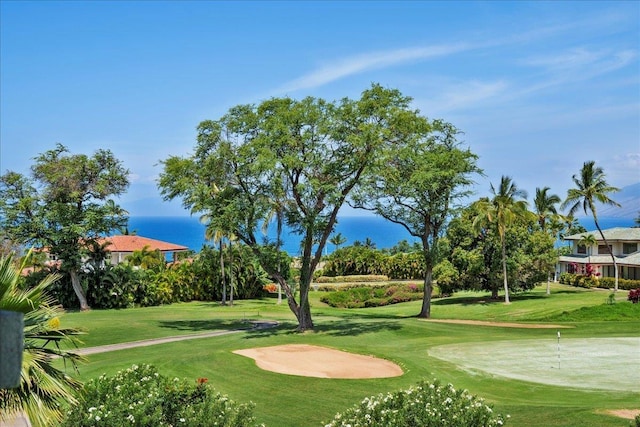 surrounding community featuring a lawn and view of golf course