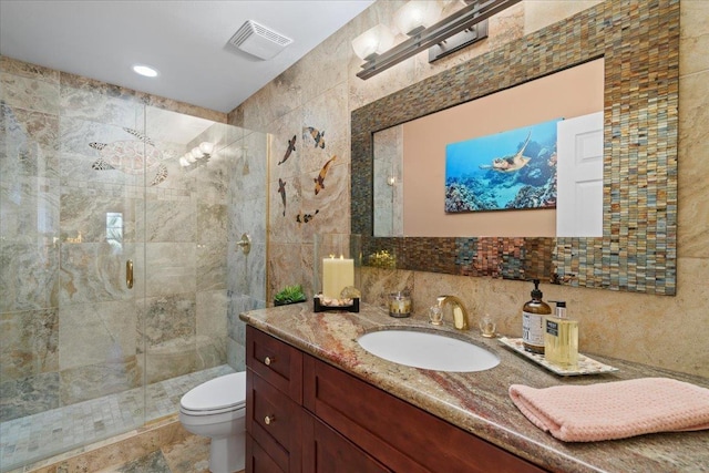 full bathroom with visible vents, tile walls, a shower stall, vanity, and toilet