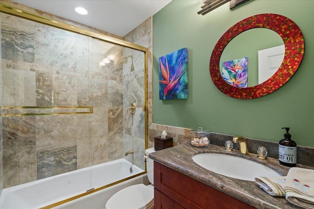 full bath featuring vanity, bath / shower combo with glass door, and toilet