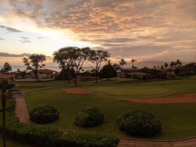 surrounding community with view of golf course and a yard