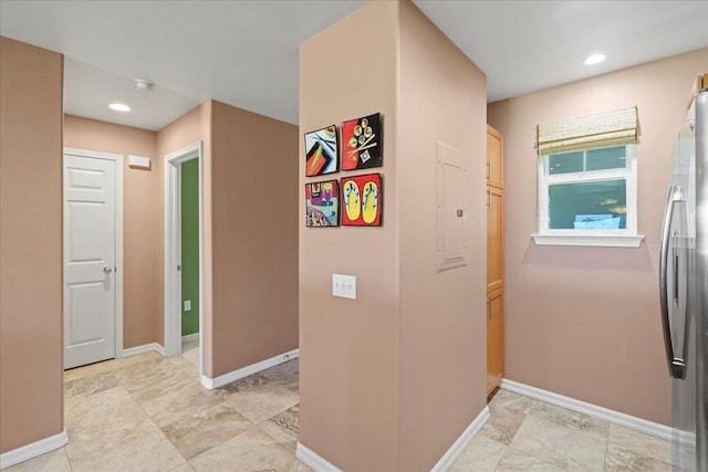 hallway featuring baseboards and recessed lighting
