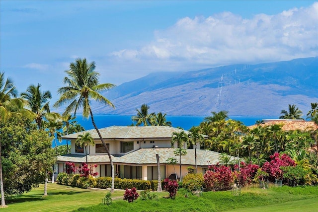 back of property featuring a lawn and a mountain view