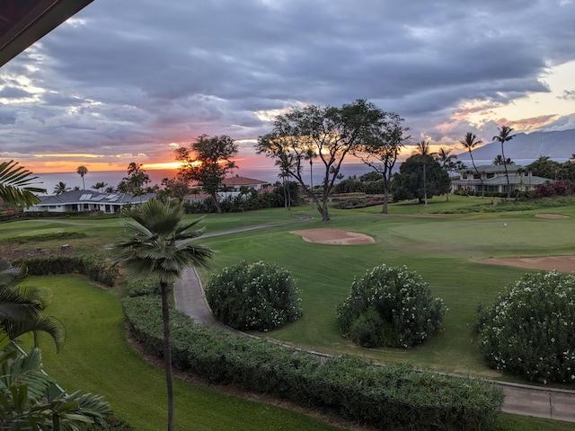 view of property's community featuring a lawn, a mountain view, and golf course view