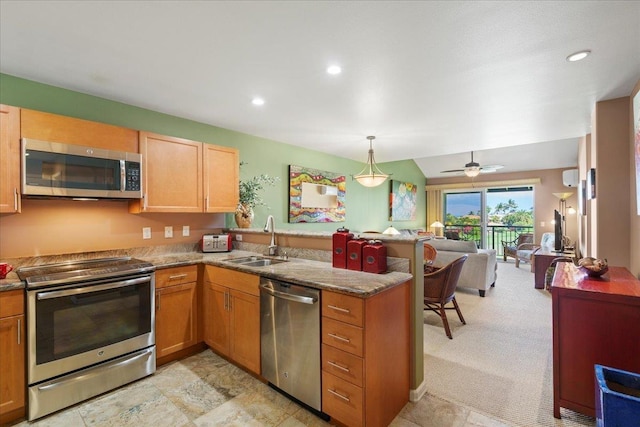 kitchen featuring appliances with stainless steel finishes, a sink, a peninsula, open floor plan, and recessed lighting