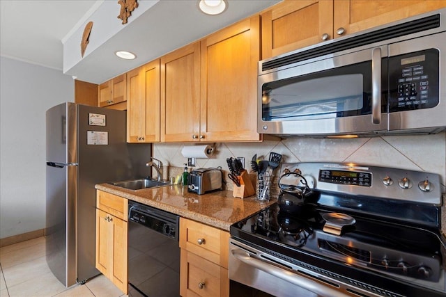 kitchen with a sink, light tile patterned floors, tasteful backsplash, and stainless steel appliances