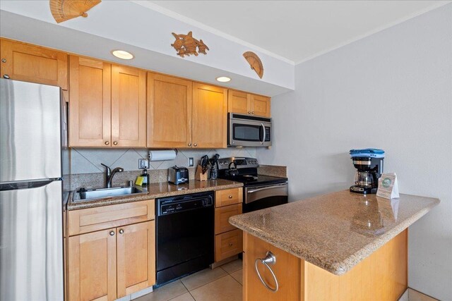 kitchen with a sink, stainless steel appliances, a peninsula, light tile patterned floors, and tasteful backsplash