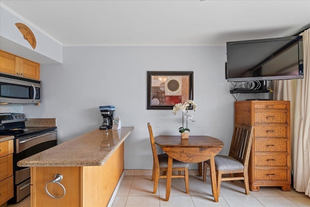 kitchen featuring ornamental molding, a peninsula, stone countertops, light tile patterned floors, and stainless steel appliances