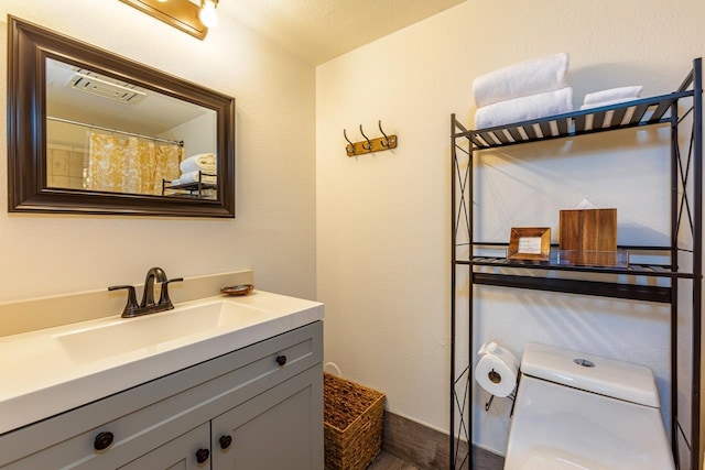 bathroom featuring vanity and toilet