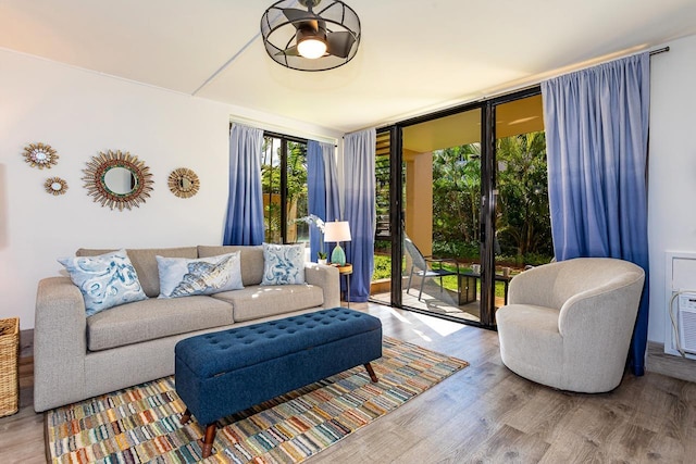 living room featuring ceiling fan, floor to ceiling windows, and light wood-type flooring