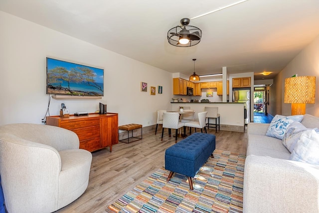 living room featuring ceiling fan and light hardwood / wood-style flooring