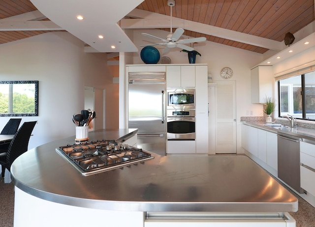 kitchen with built in appliances, vaulted ceiling with beams, white cabinetry, a center island, and modern cabinets