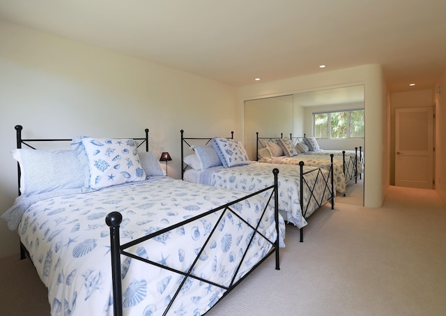 bedroom featuring recessed lighting, a closet, and light colored carpet