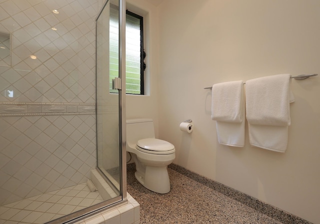 full bath featuring a stall shower and toilet