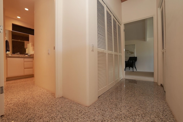 corridor featuring a heating unit, speckled floor, and recessed lighting