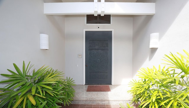 doorway to property featuring stucco siding