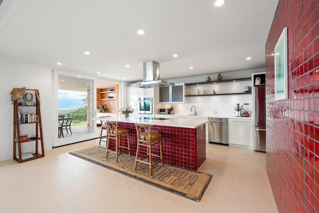 kitchen featuring a center island, sink, stainless steel appliances, island range hood, and a breakfast bar