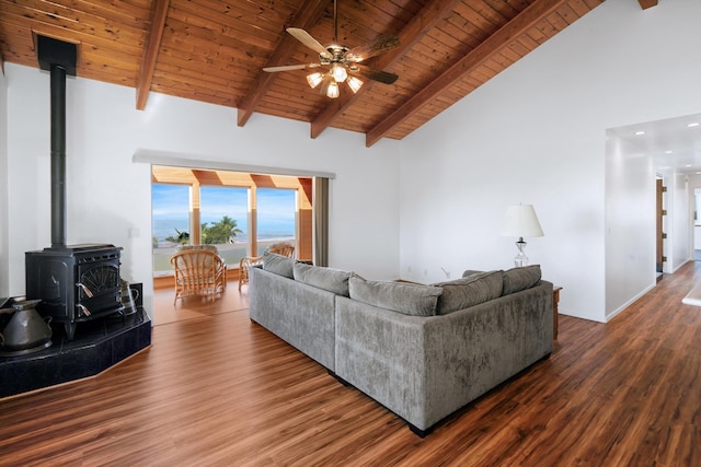 living room featuring a wood stove, ceiling fan, wooden ceiling, beamed ceiling, and hardwood / wood-style floors