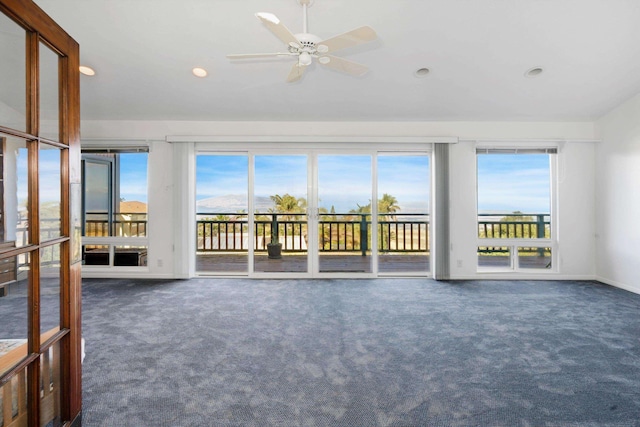 interior space with ceiling fan and dark colored carpet