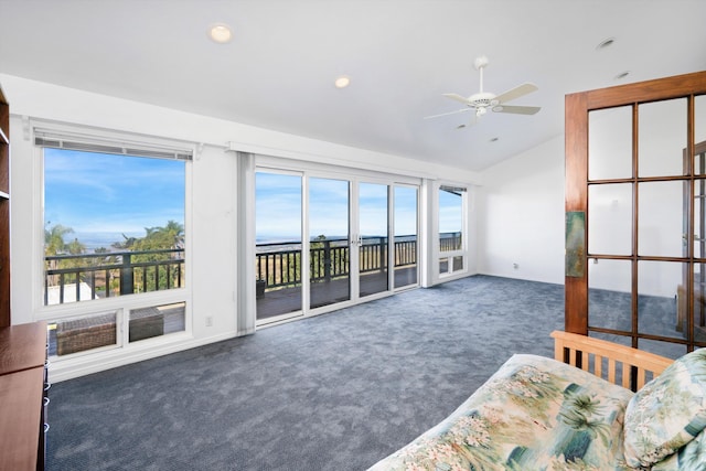 unfurnished living room with dark carpet, ceiling fan, and lofted ceiling