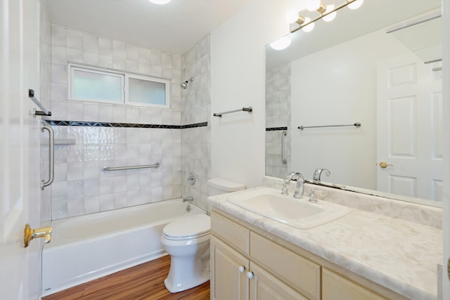 full bathroom with vanity, hardwood / wood-style flooring, toilet, and tiled shower / bath