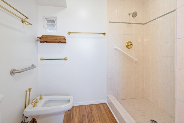 bathroom featuring hardwood / wood-style floors, a bidet, and tiled shower