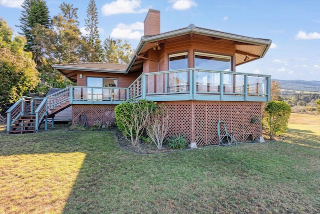 back of house with a lawn and a deck