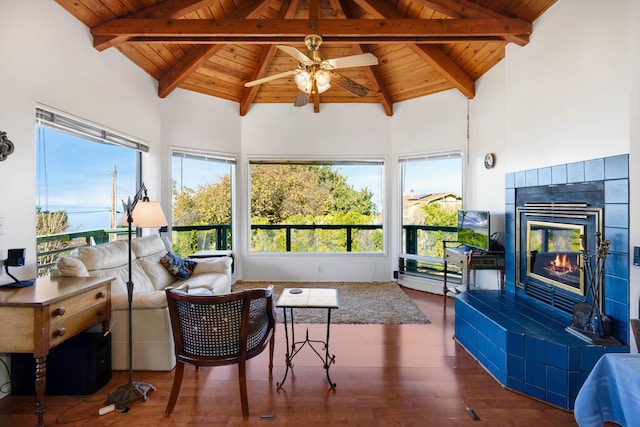 sunroom featuring a fireplace, vaulted ceiling with beams, a wealth of natural light, and ceiling fan