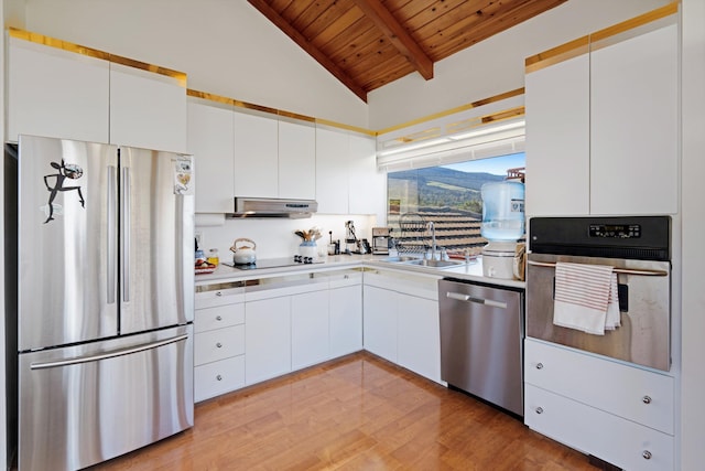 kitchen with wooden ceiling, lofted ceiling with beams, sink, white cabinetry, and stainless steel appliances