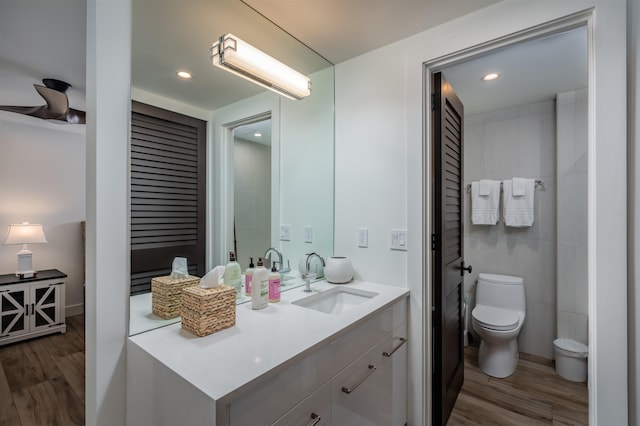 bathroom with toilet, vanity, and hardwood / wood-style flooring